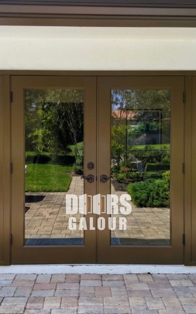 Wooden double doors with glass panels and black handles set in a white doorframe on a brick step.