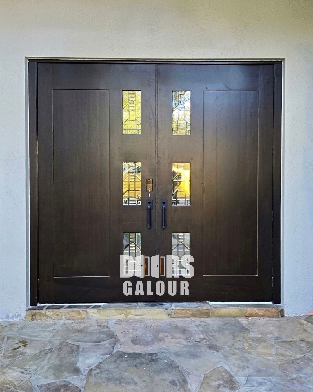 Gray double doors with glass panels and long silver handles.