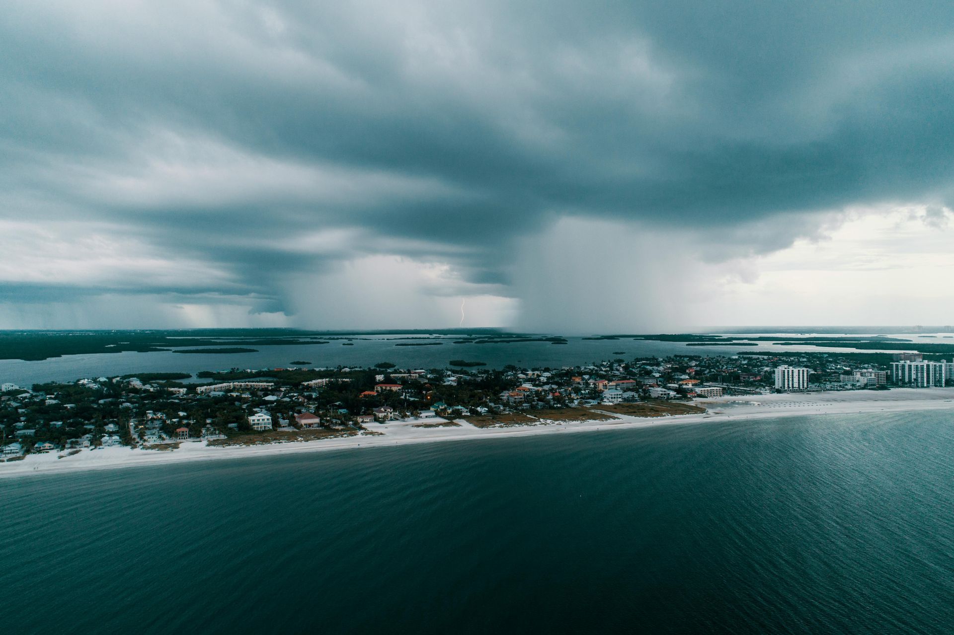 Storm clouds over a coastal town and ocean shoreline.