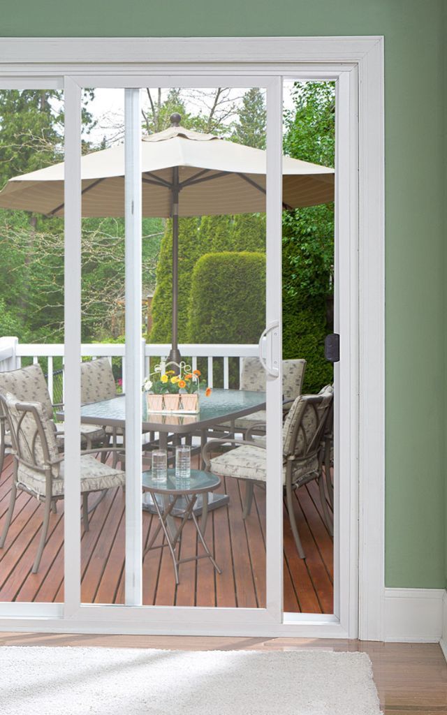 Sliding glass doors open to a pool and backyard dining area. The scene is bright with sunlight.