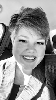 A man with a beard is holding his hand to his chin in a black and white photo.