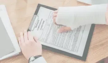 A person with a cast on their arm is signing a document on a clipboard.