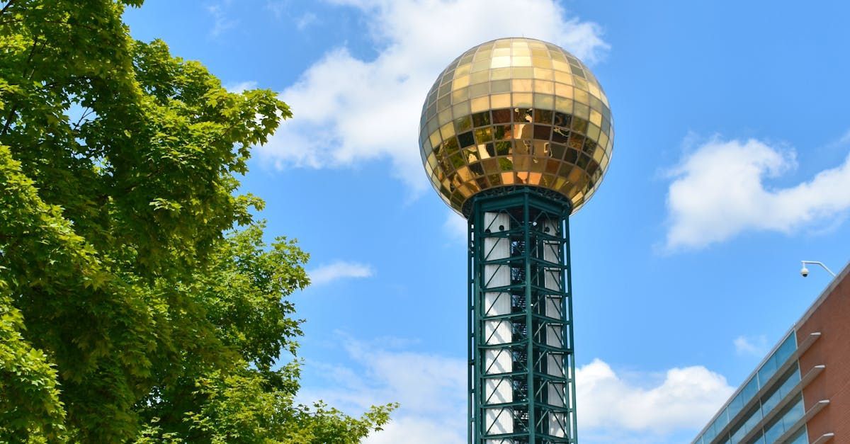 A tall tower with a gold ball on top of it.