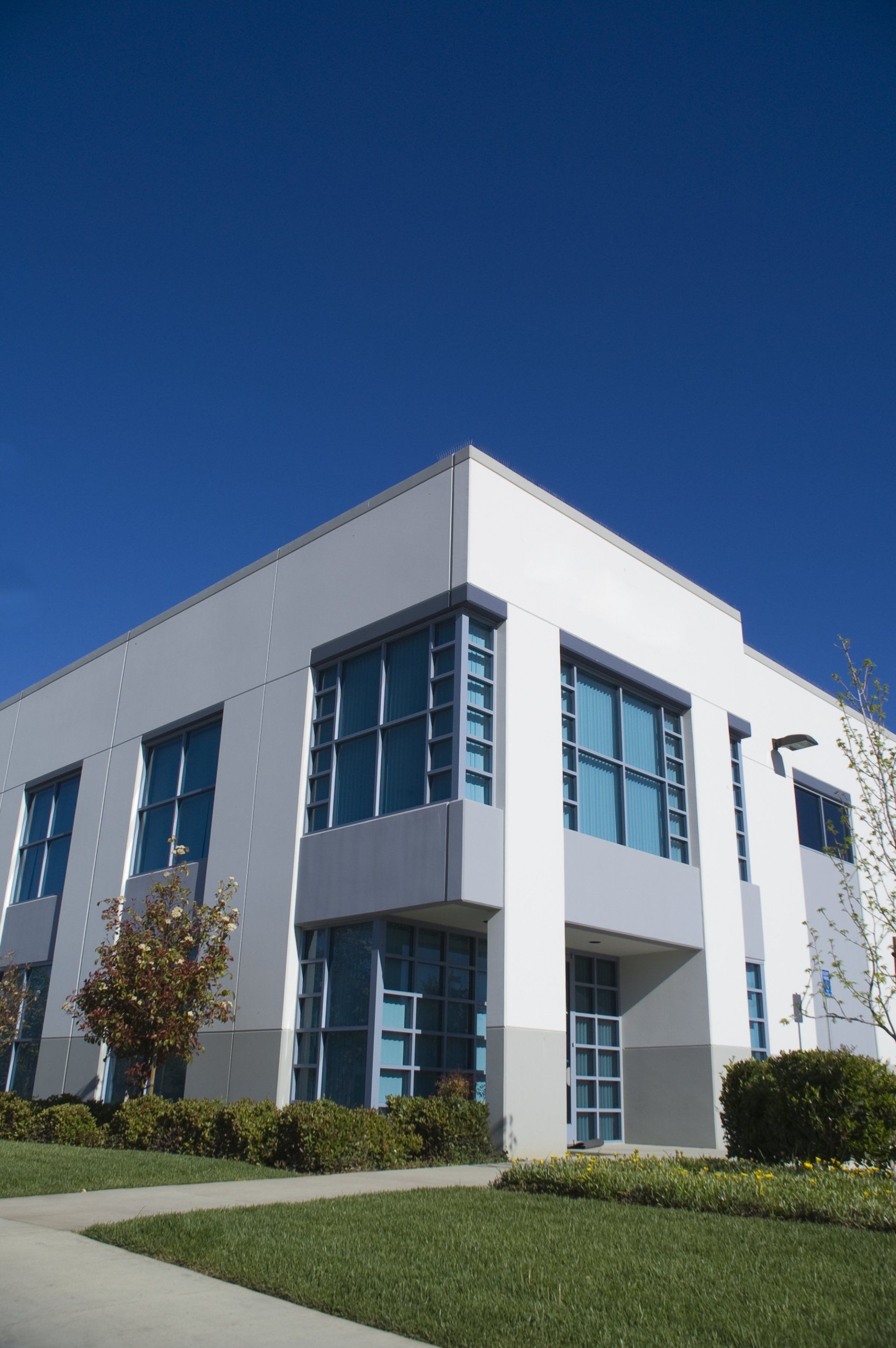 Un grand bâtiment blanc avec beaucoup de fenêtres par une journée ensoleillée