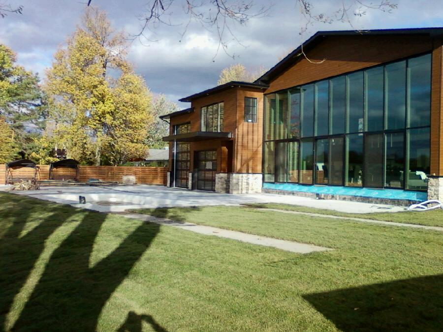 Un grand bâtiment avec de nombreuses fenêtres se trouve au sommet d'un champ verdoyant.