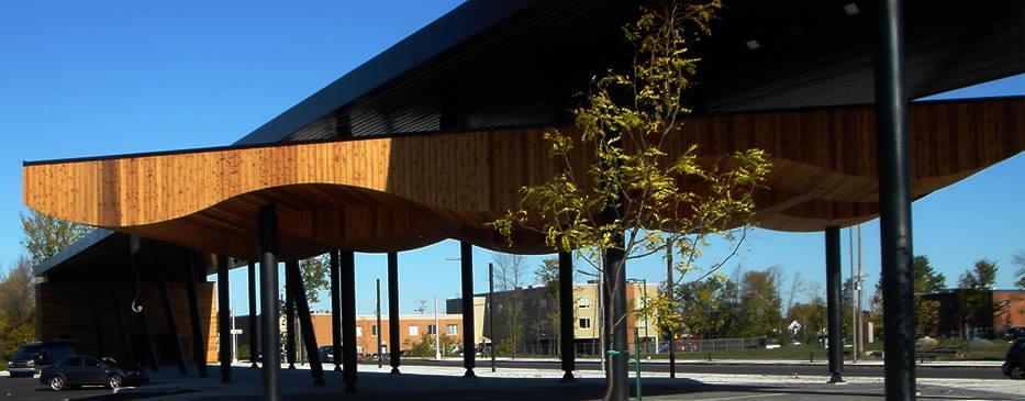 Un bâtiment avec un toit en bois et un arbre devant