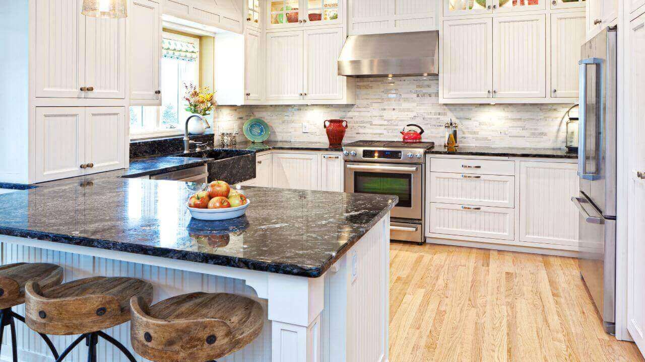 Modern kitchen featuring white cabinets and black counter tops.