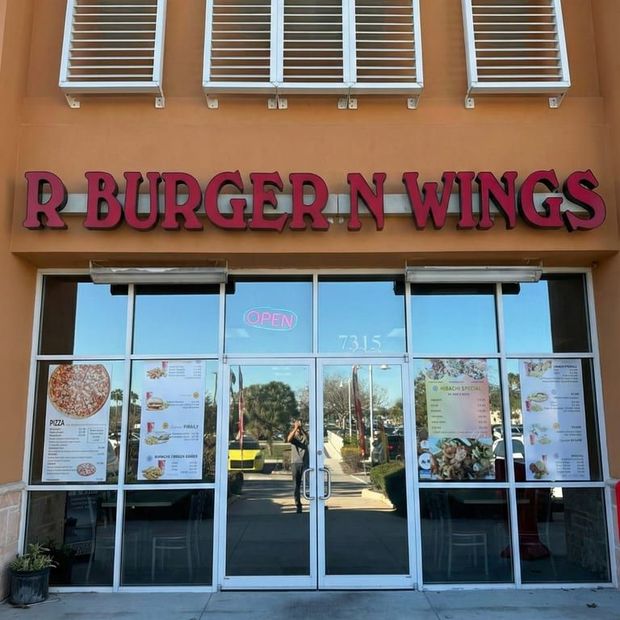 R Burger N Wings storefront with large red sign and glass entrance under tan building facade