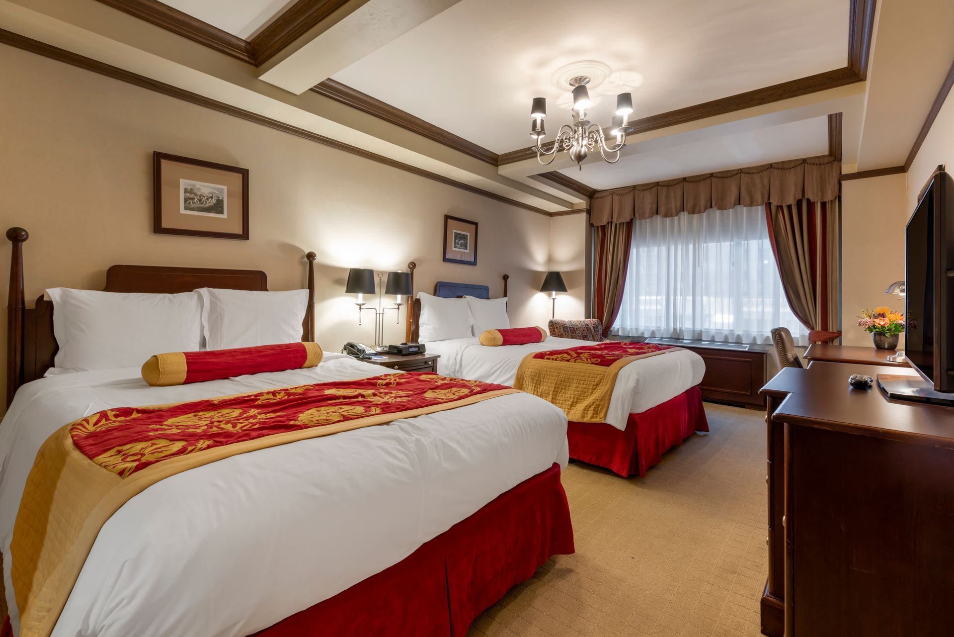 A hotel room with two beds and a television