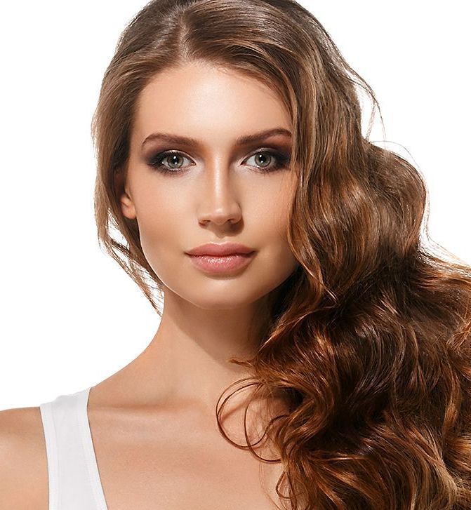 A woman with long brown hair is wearing a white tank top