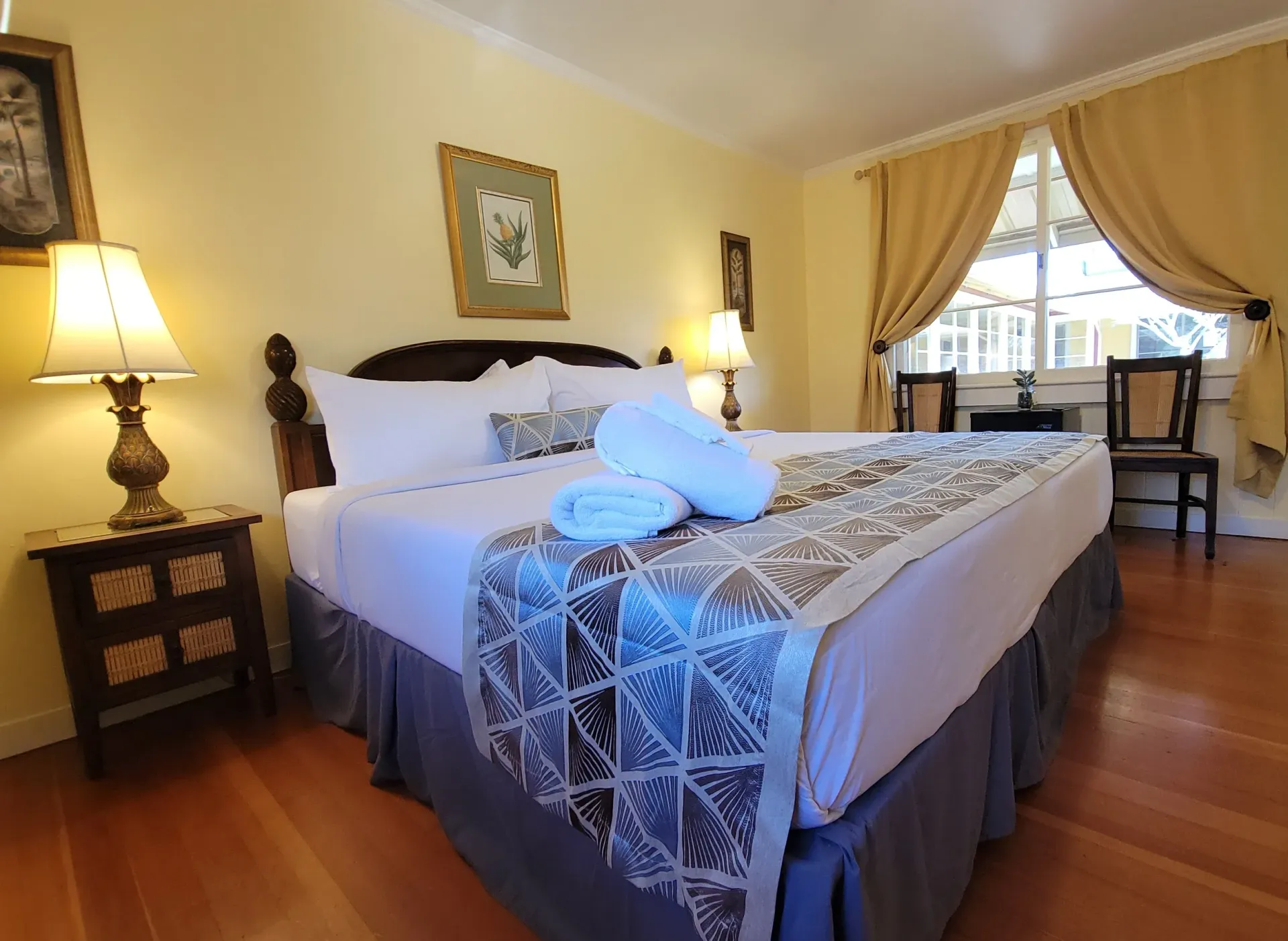 A hotel room with a king size bed and two lamps