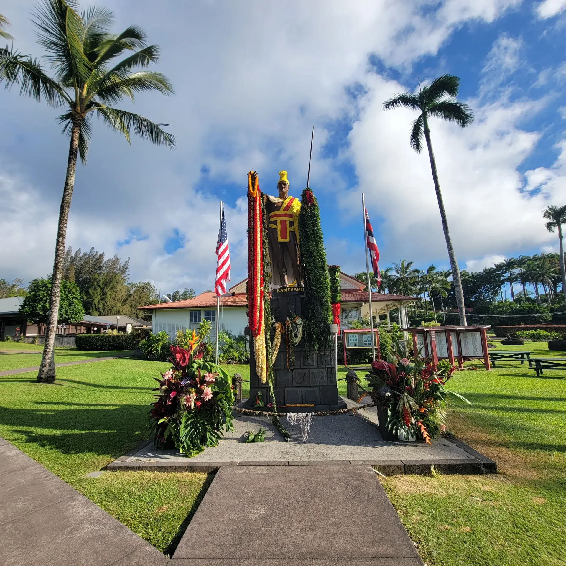 A statue of a man holding a flag in front of a building.