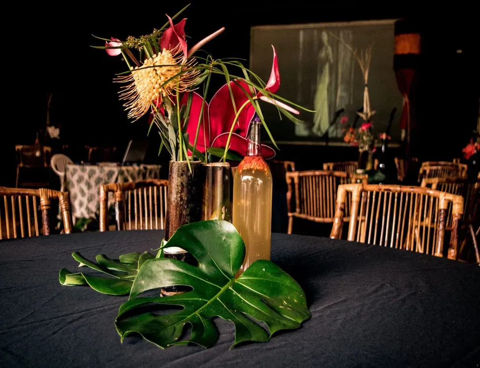 A table with a bottle of wine and flowers on it