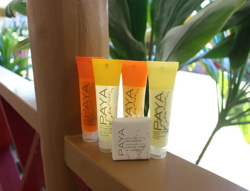 Four tubes of paya soap sit on a railing