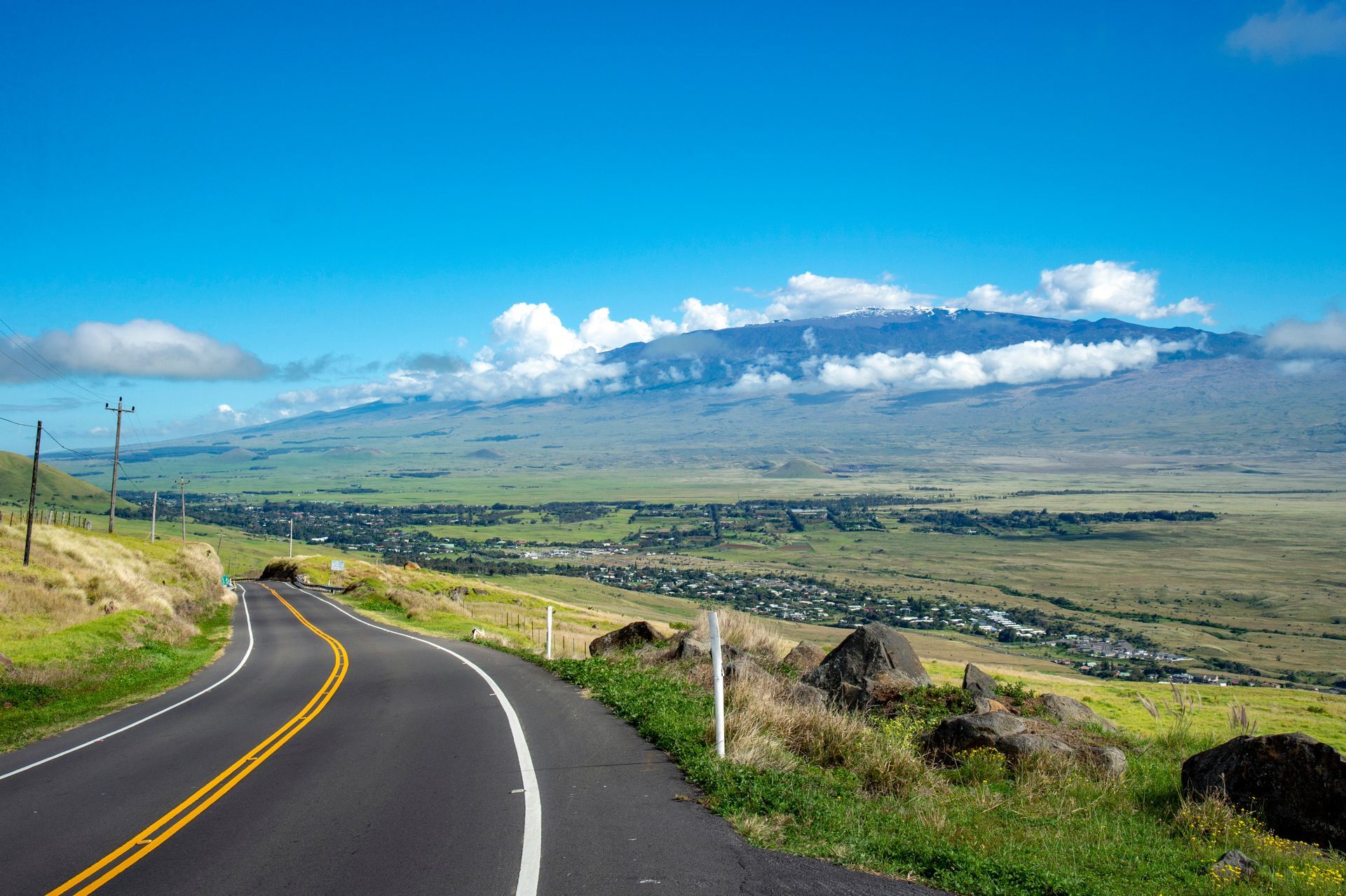 A road going through a valley with a mountain in the background.