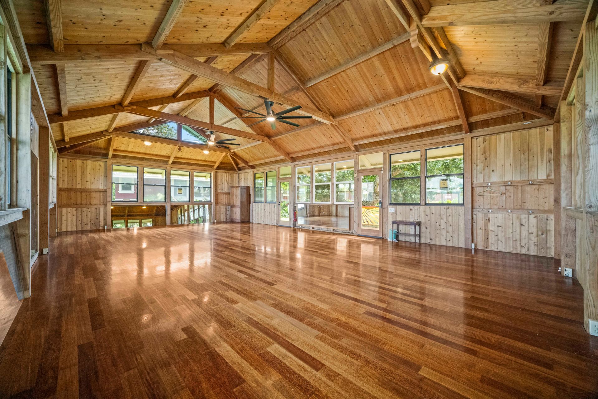 A large room with tables and chairs set up for a wedding reception