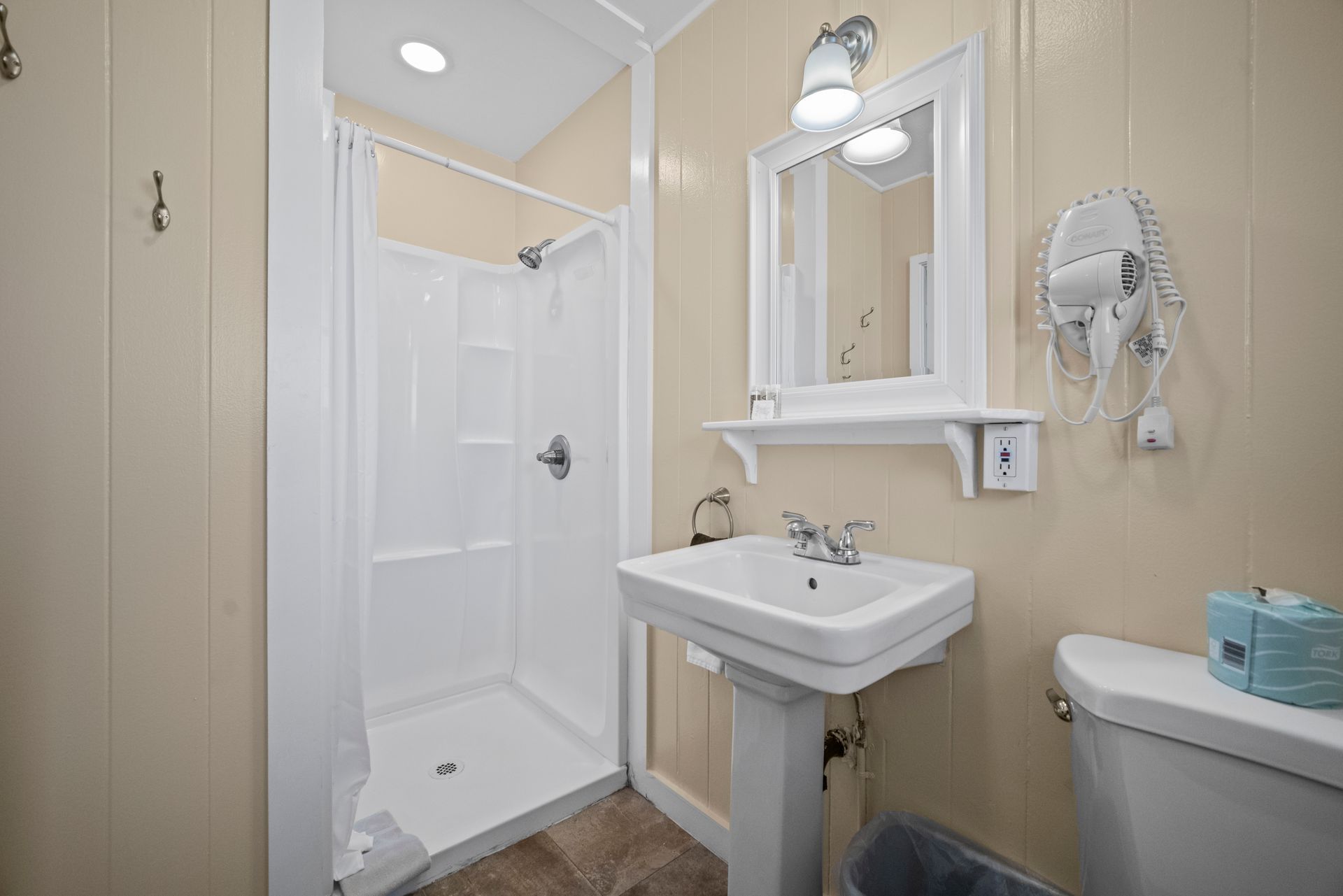 A bathroom with a sink toilet and mirror