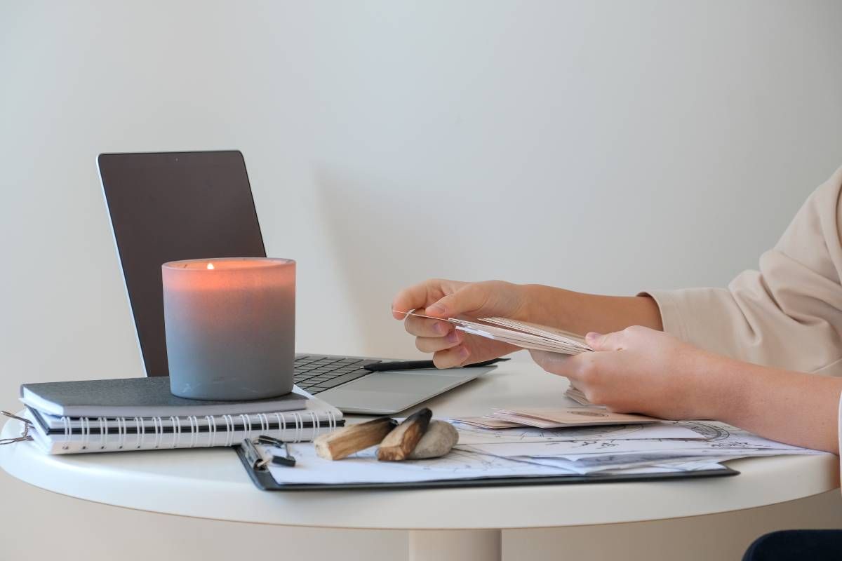 Person reviewing La Mesa cremation pre-planning documents with candle and laptop on table