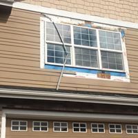 A house with a garage door and a window that is missing.