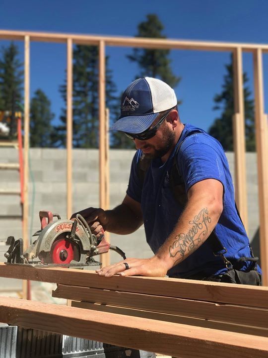 A man is using a circular saw to cut a piece of wood.