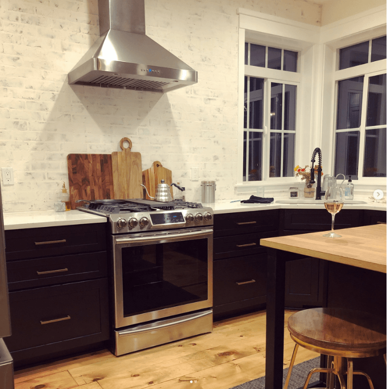 A kitchen with stainless steel appliances and black cabinets