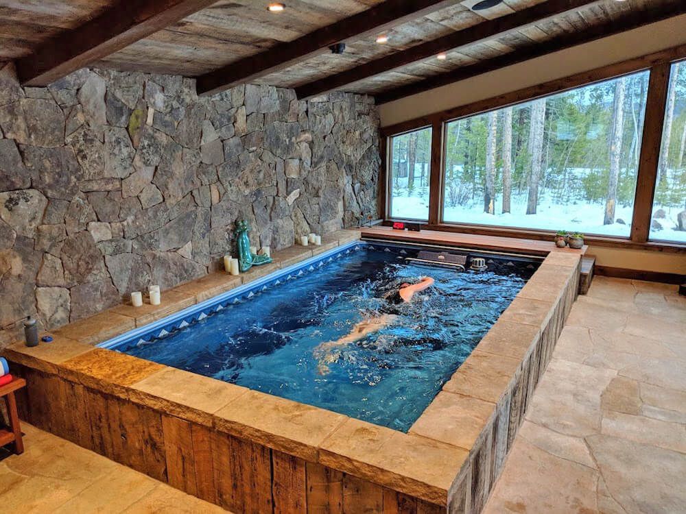 A man is swimming in a large indoor pool.