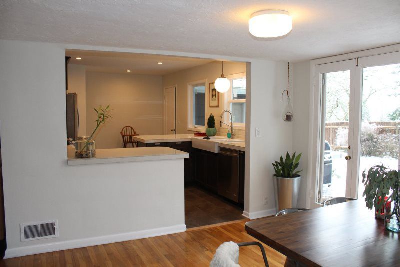 A kitchen and dining room are connected by a sliding glass door.