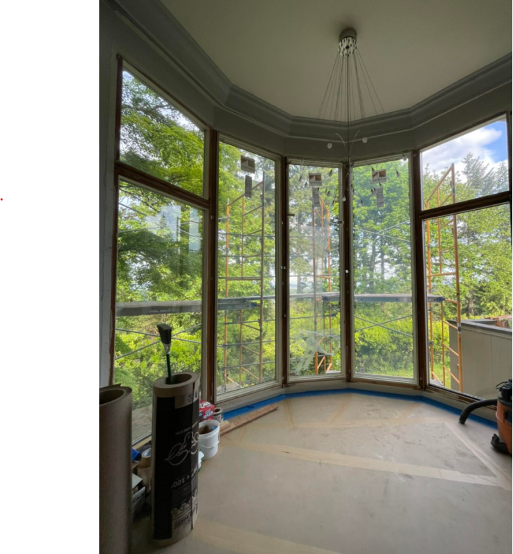 A room with a lot of windows and trees in the background