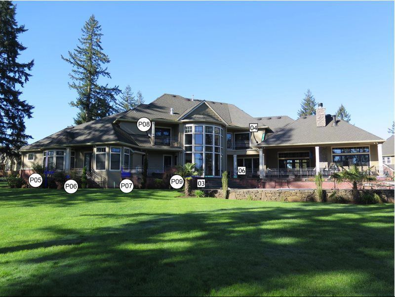 A large house with a lot of windows is surrounded by trees
