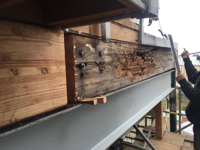 A man is working on a wooden structure with a ladder.