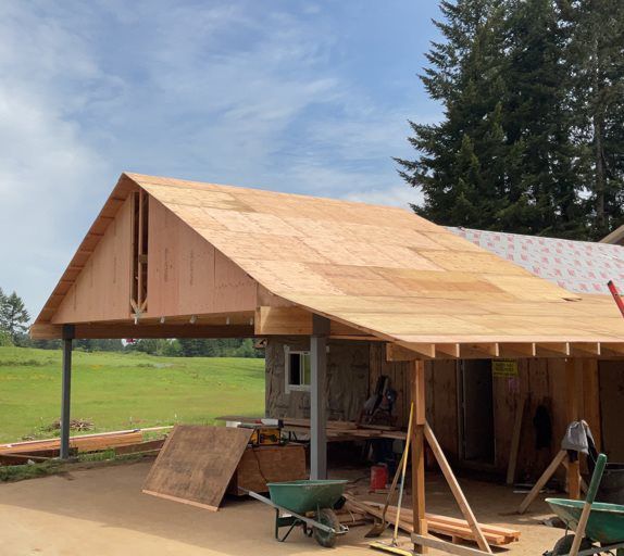 A house under construction with a wheelbarrow in front of it