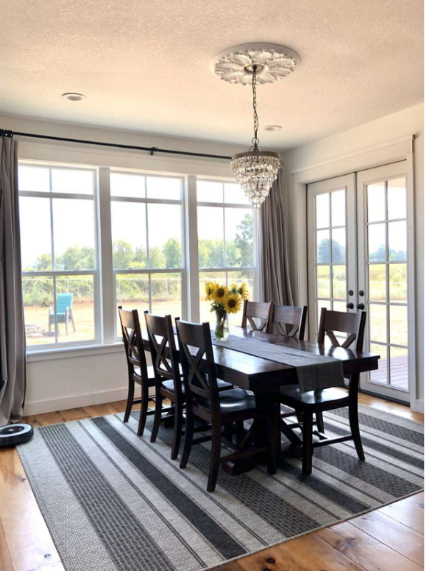 A dining room with a table and chairs and a rug