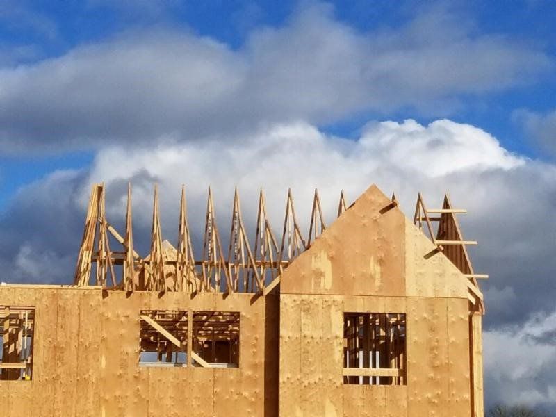 A house under construction with a blue sky in the background
