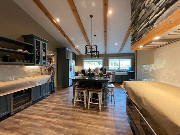 A kitchen with a large island and stools in it
