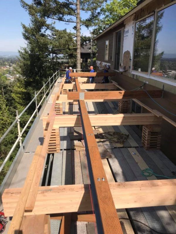 A wooden deck is being built on the side of a house
