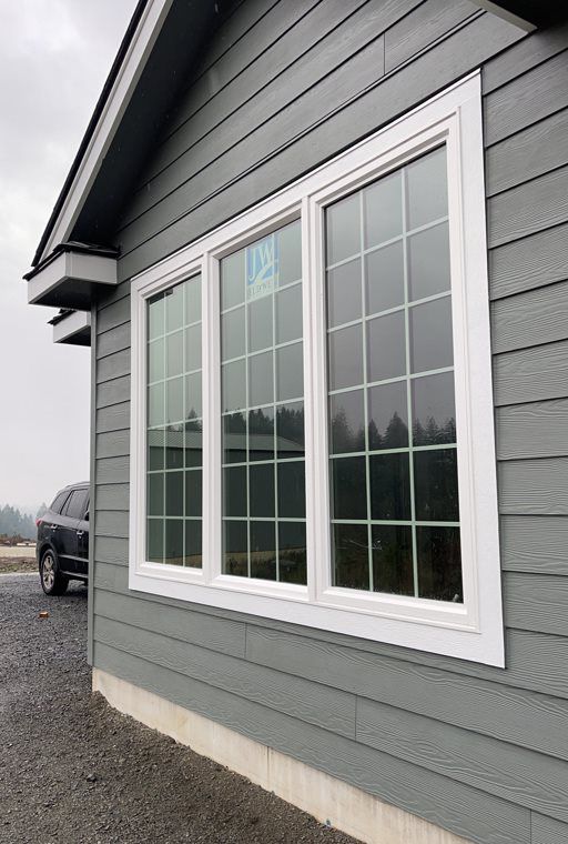 A house with three windows and a car parked in front of it.