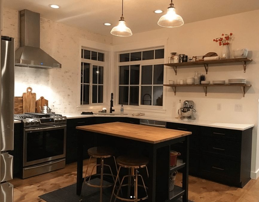 A kitchen with stainless steel appliances and a wooden table.