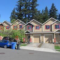A row of houses with a blue truck parked in front of them.