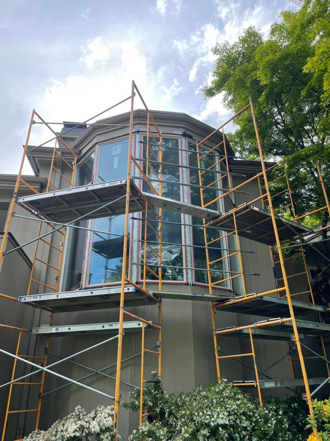 A large house is being remodeled with scaffolding around it.