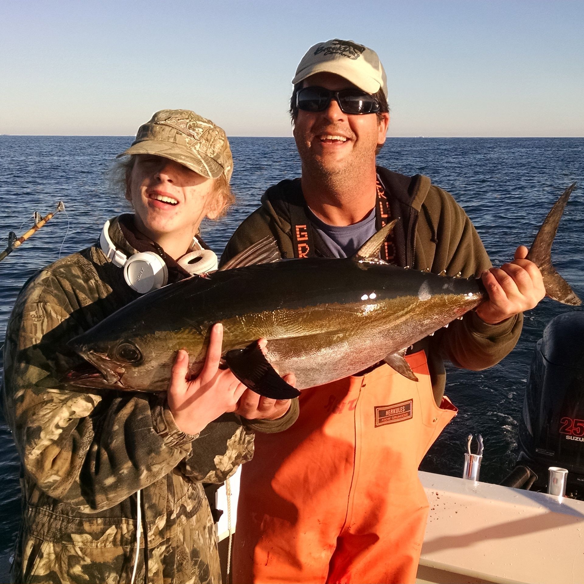 A man and a girl are holding a large fish in their hands