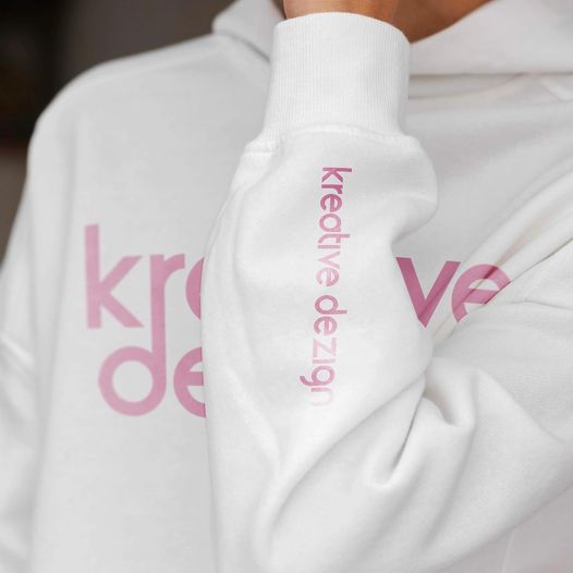 A person wearing a white hoodie with the word kreative design on the sleeve.