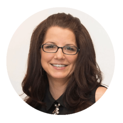 A woman wearing glasses and a black shirt smiles for the camera