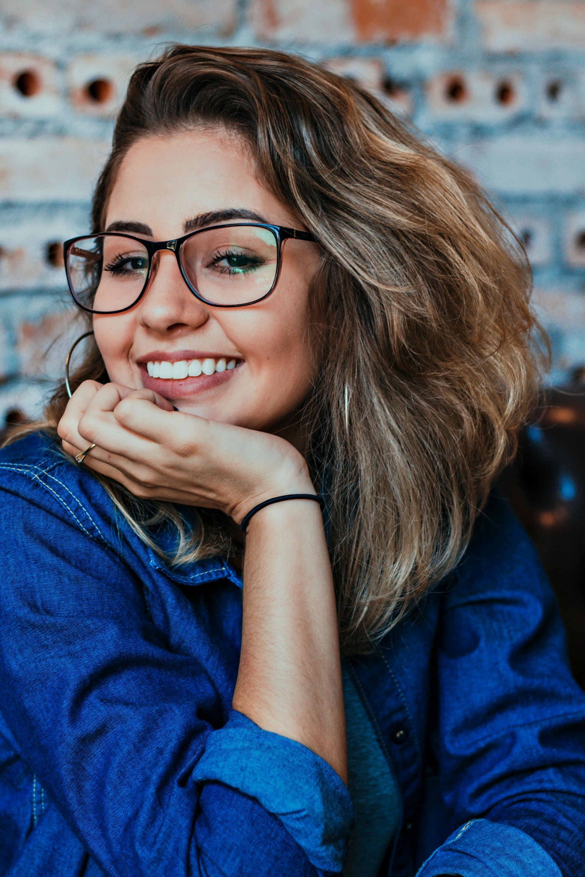 A woman smiling with her hand on her chin