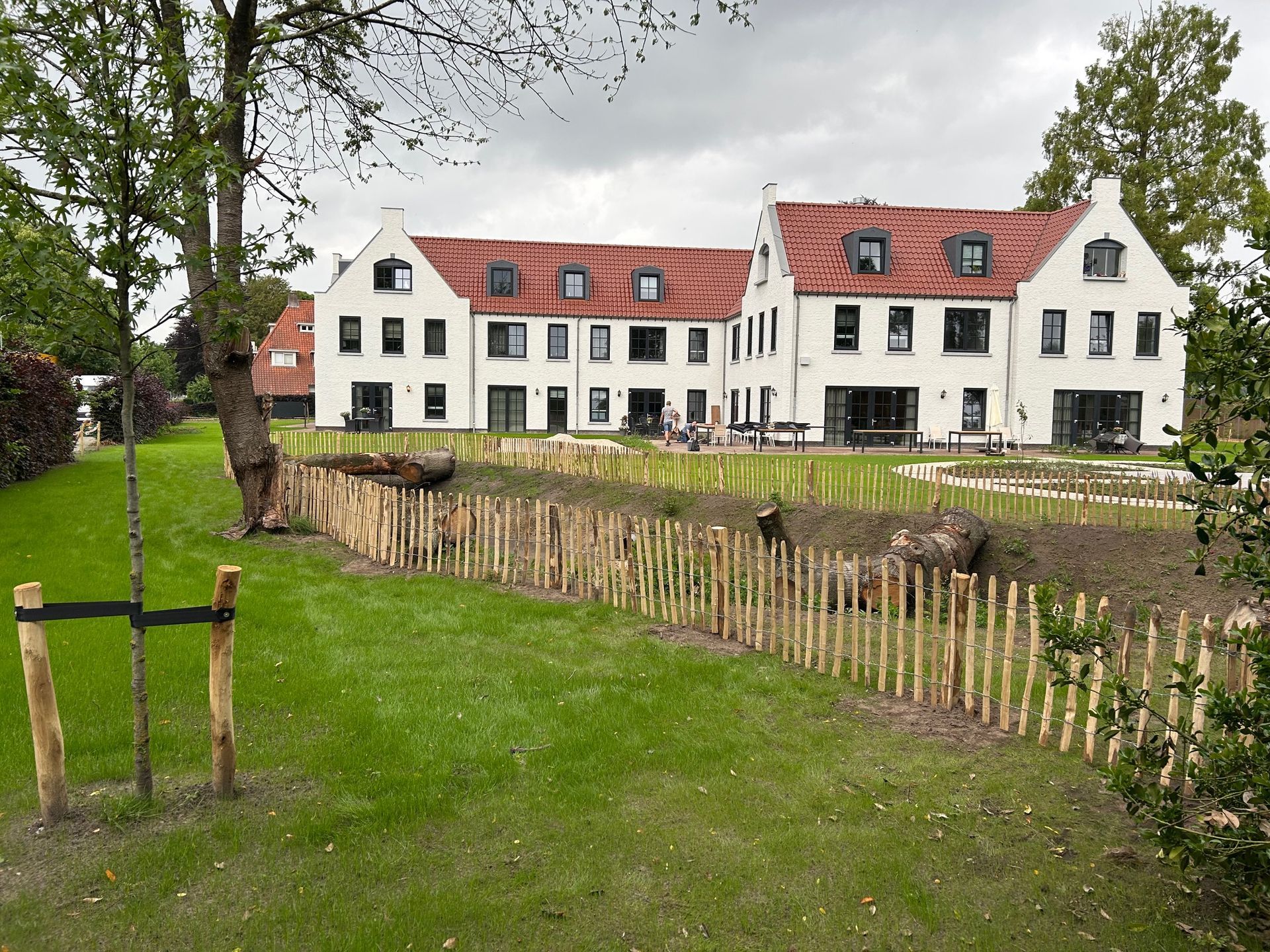 Een houten hekwerk rondom een wadi in een tuin.