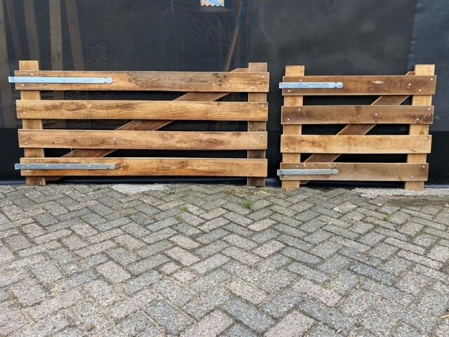 Op een stenen trottoir staan ​​twee robinia landhekken.