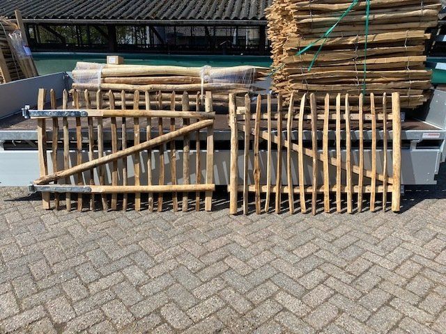 Op een aanhangwagen staan ​​twee kastanje houten tuinpoortjes.