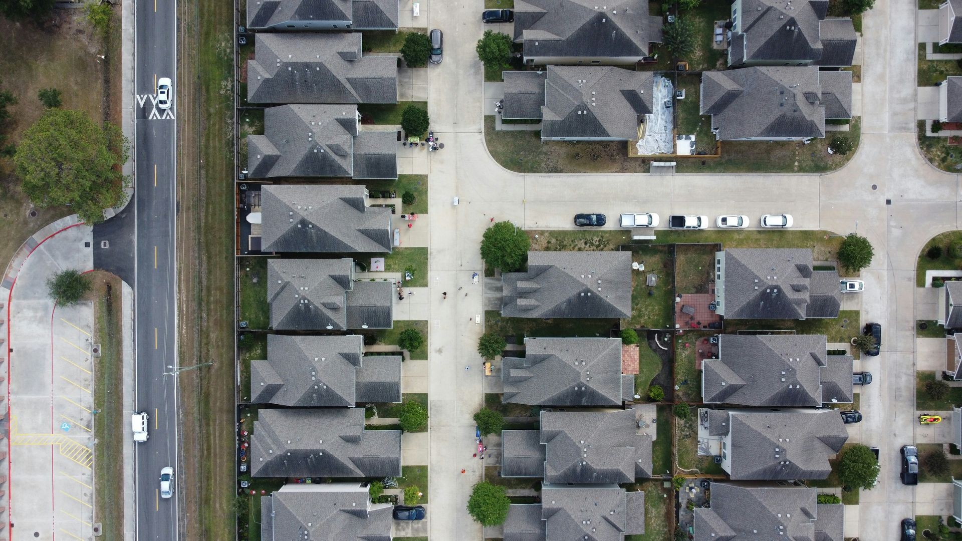 An aerial photograph of a suburban neighborhood. Rows of closely spaced single-family homes.