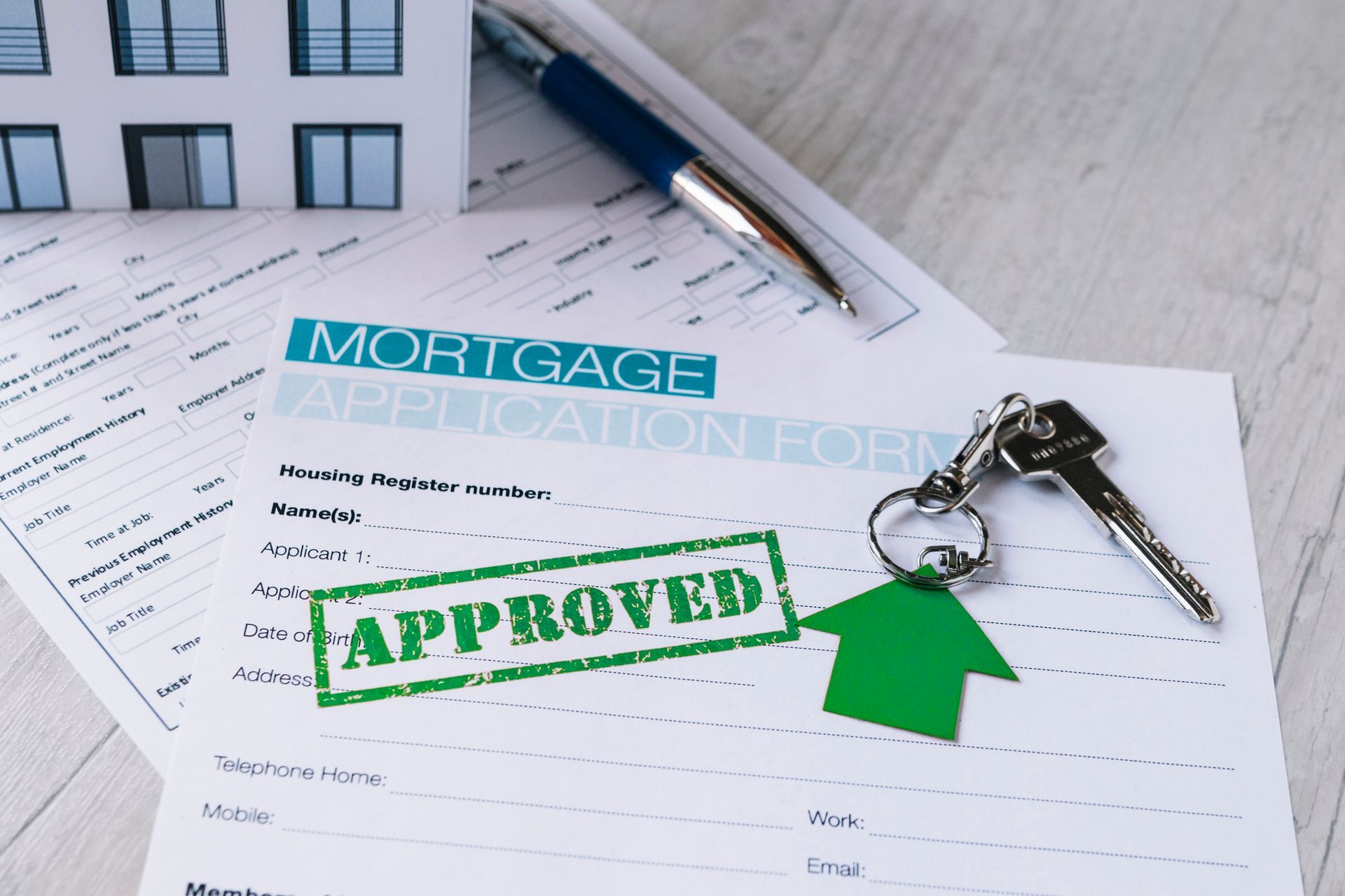 Mortgage pre-approval documents including application forms, keys, and an 'Approved' stamp