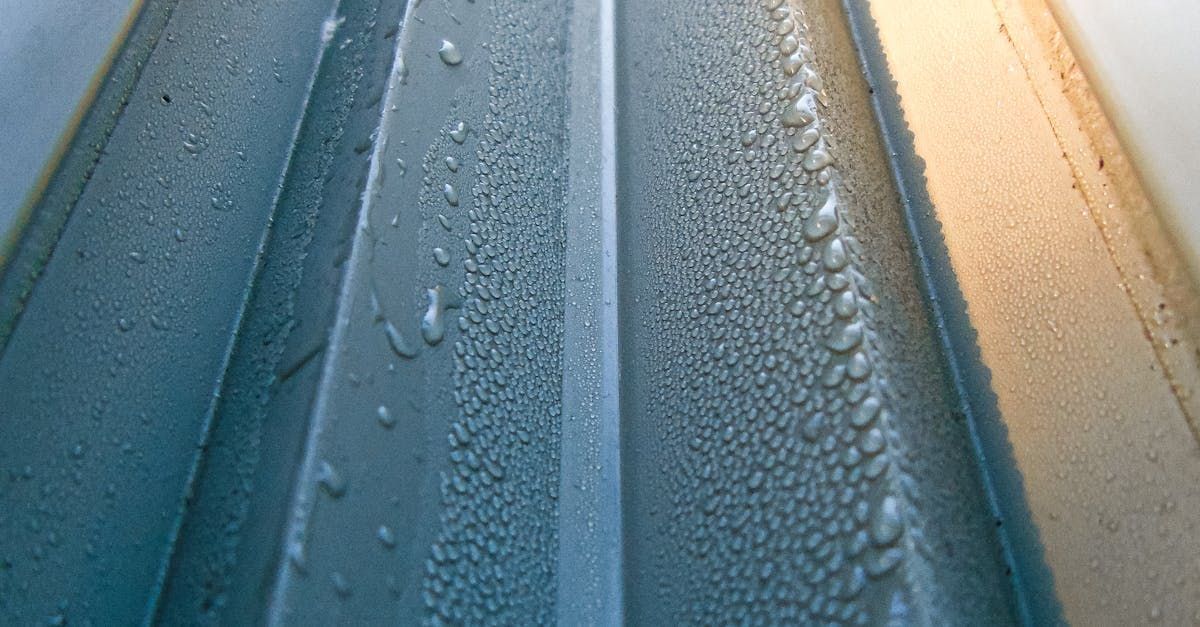 A close up of a metal surface with water drops on it.