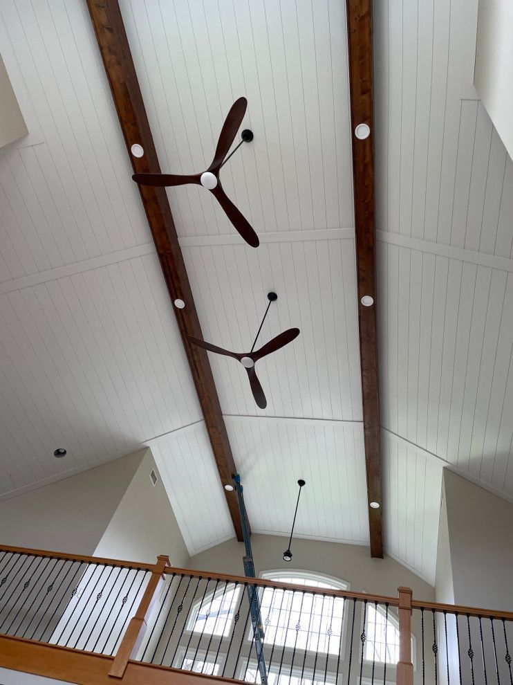 Two ceiling fans are hanging from the ceiling of a house